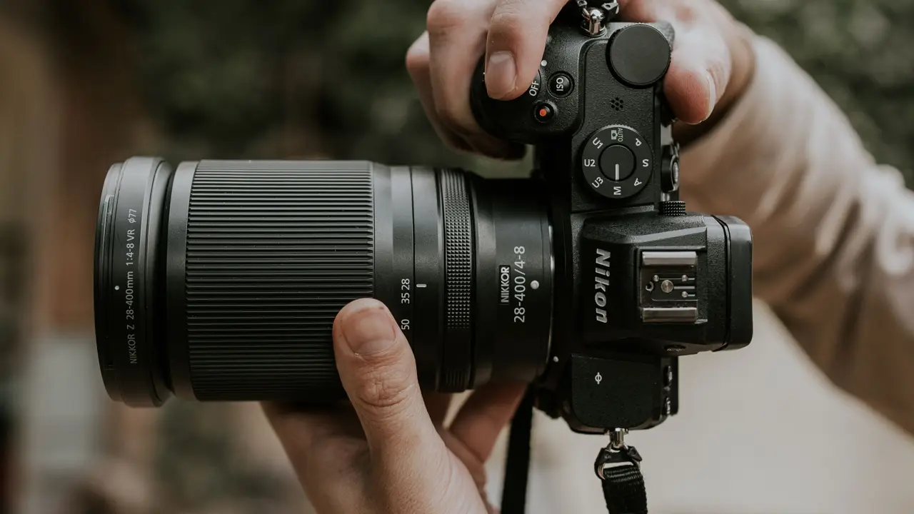 A photographer holding a camera with a zoom lens