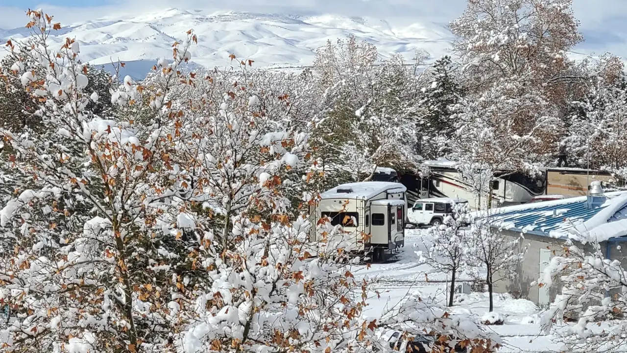 RV sites under fresh snow with mountains in the distance