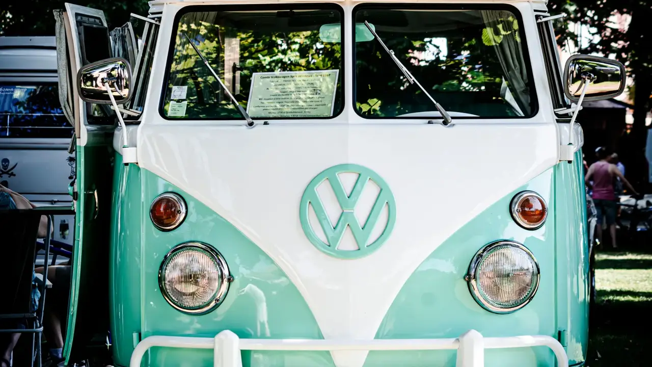 A vintage camper van parked in the shade